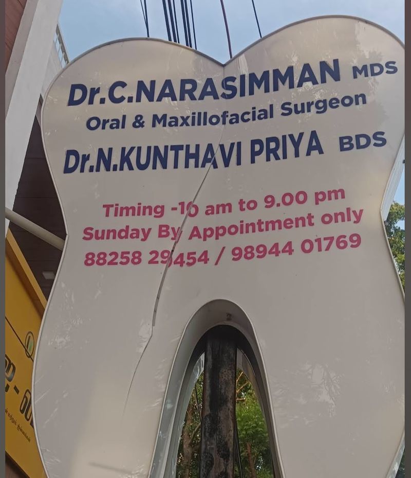 Tooth-shaped signboard listing Dr. C Narasimman MDS and Dr. N Kunthavi Priya BDS with timings