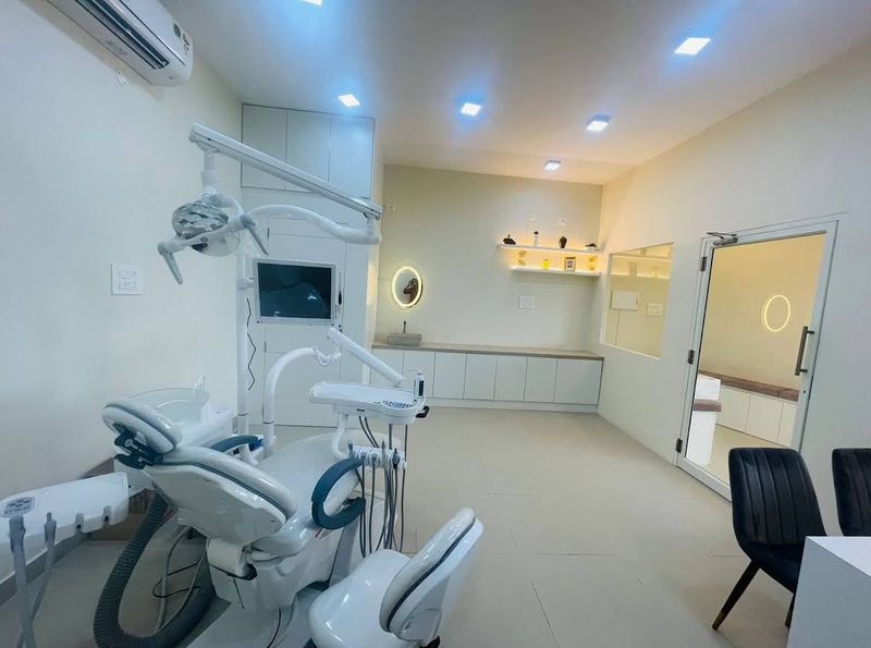 Treatment room at V Dent with dental chair, overhead light and monitor