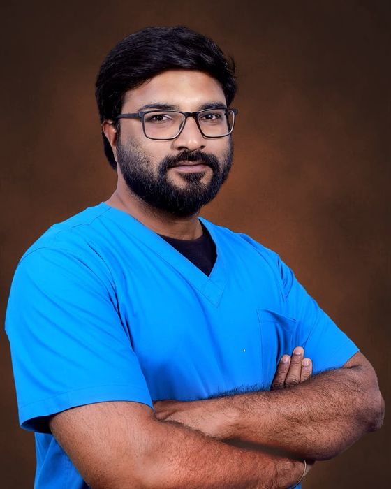 Portrait of Dr. C Narasimman in blue scrubs